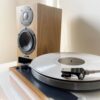 PMC active twenty5.21i active bookshelf speakers next to a vinyl turntable