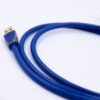 Sinine USB-A kaabel kuldse pistikuga valgel taustal, kaabel lähedal silmusesse keritud.