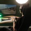 A man engrossed in gaming with a controller and the Meze 109 Pro headphones paired with the Boom Mic
