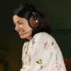 A smiling woman makes a work-related video call using the Meze 99 Classics and Meze Boom Mic