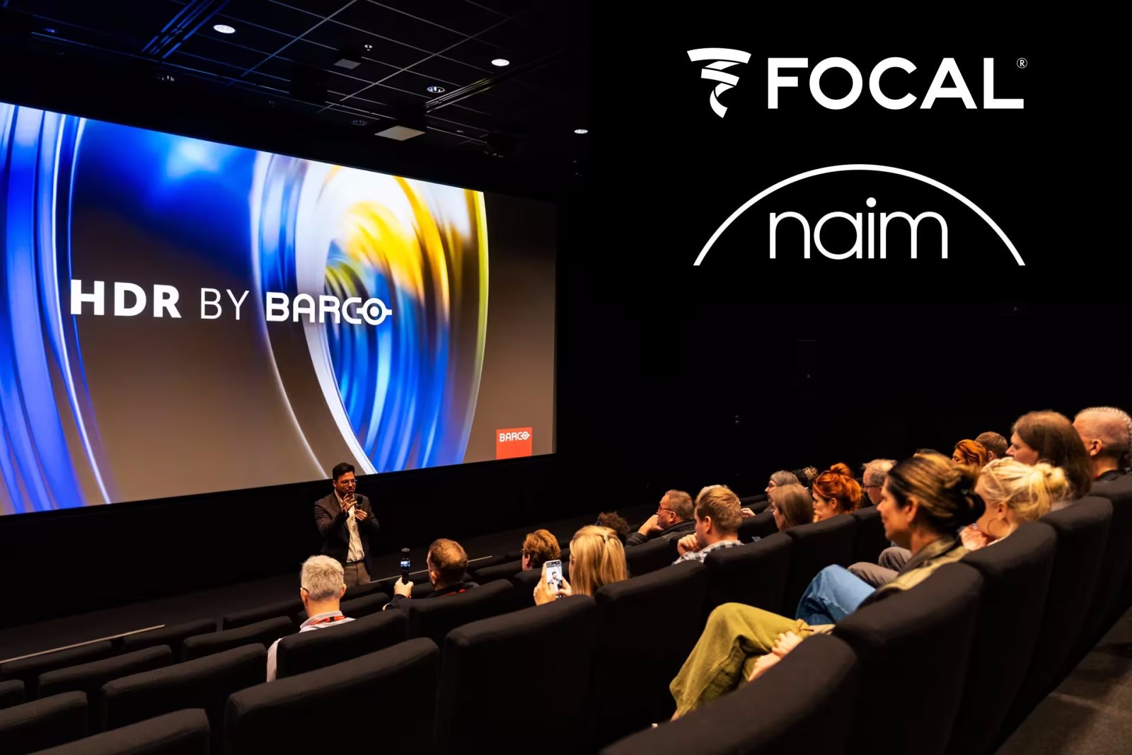Pildikollaaž, kus Focali ja Naimi audiobrändide logod on kombineeritud fotoga renoveeritud Barco Experience Centre'i avamiselt Kortrijkis, Belgias.